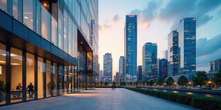 Exterior view of a modern glass and steel office building set against a city skyline.