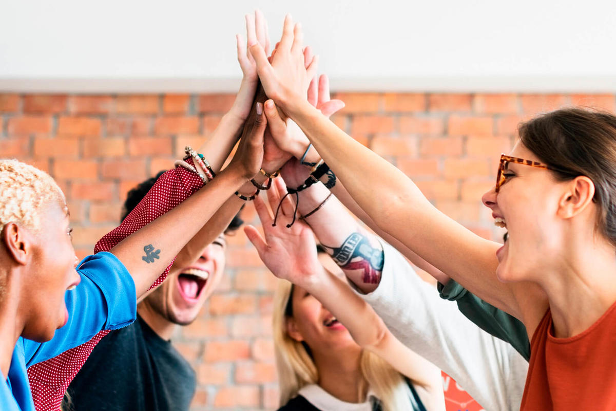 Team with hands together in the air showing success