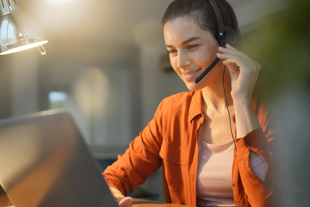 Female remote worker at home on call with headset