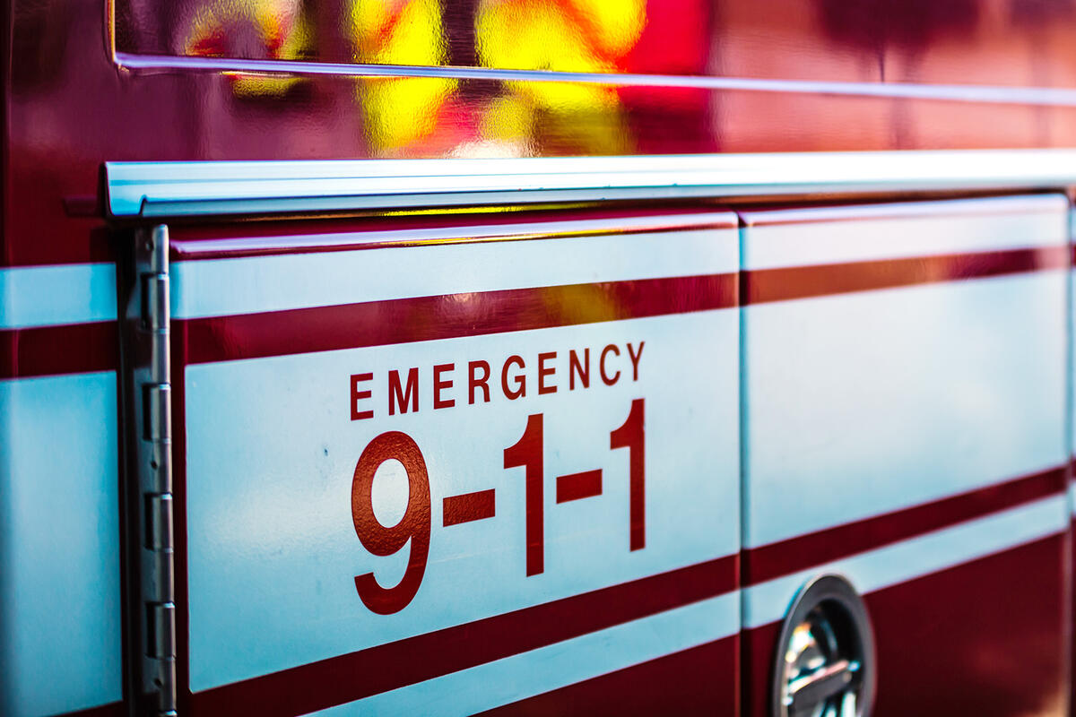 Close-up of an ambulance with the text 'Emergency 911' visible, highlighting Emergency Communications Regulation Compliance.