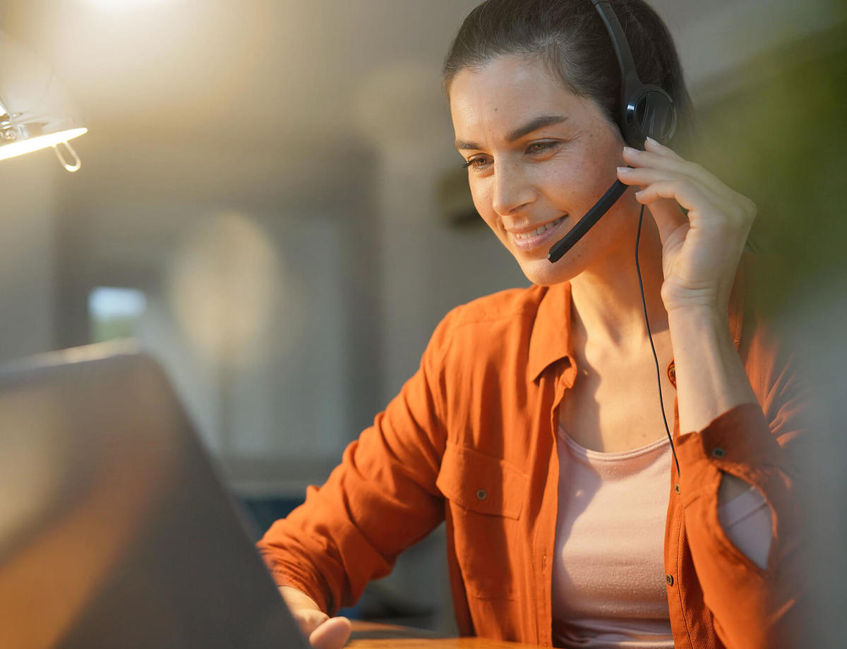 Female remote worker at home on call with headset